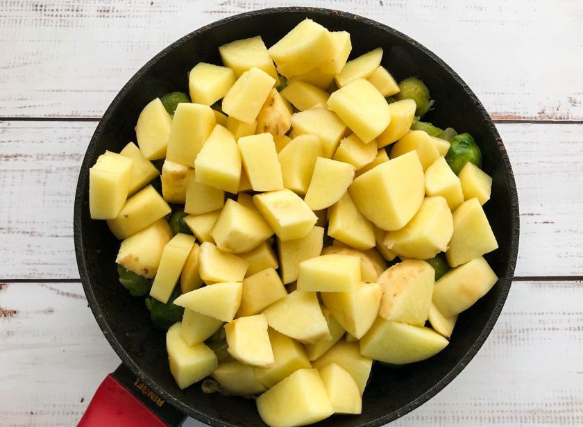 1. Этап. Тушеная брюссельская капуста с картошкой: Картофель очистите, помойте, нарежьте небольшими кусочками и выложите в сковороду.
