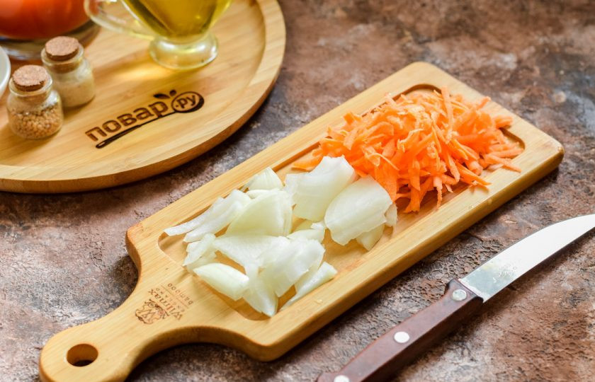 1. Этап. Закуска Казацкая на зиму: Морковь и лук очистите, сполосните. Нарежьте лук полосками, морковь натрите на средней терке.