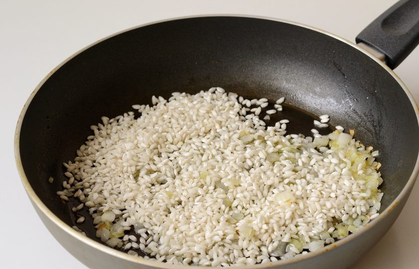 1. Этап. Ризотто Джейми Оливера: Добавьте рис к жареному луку. Перемешайте, чтобы он впитал масло. Затем влейте вино и выпаривайте до полного испарения.