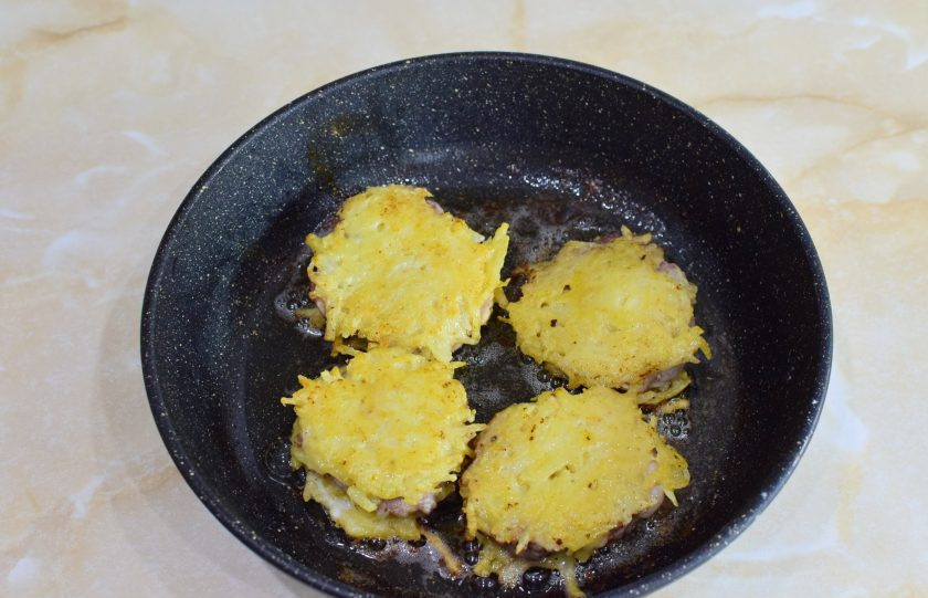 1. Этап. Свиные отбивные в картофельном кляре на сковороде: Жарьте мясо в кляре на малом огне по 4-5 минут с каждой стороны. Мясо должно успеть прожариться внутри, но картофель не должен начать подгорать. Чтобы мясо приготовилось, накрывайте сковороду крышкой.