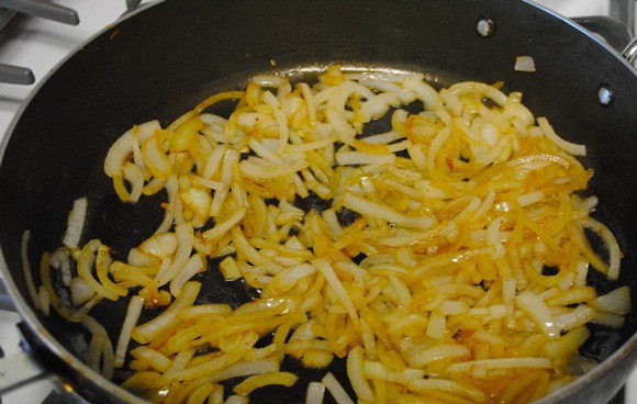 1. Этап. Кролик в горчичном соусе: Теперь в сотейник доливаем еще немного масла и обжариваем на нем нарезанный полукольцами лук до мягкости, перекладываем его к кролику.