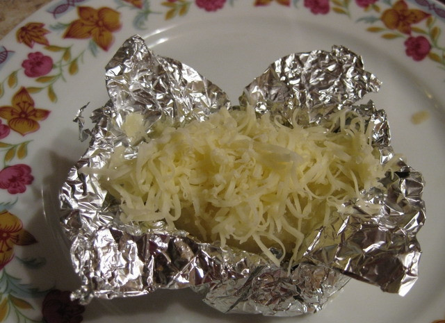 1. Этап. Картофель в фольге с сыром: Посыпать сверху остатками тертого сыра.