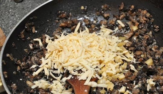 1. Этап. Куриное филе с грибами в духовке: Порежьте мелкими кусочками грибы и лук. Разогрейте сковороду. Налейте в нее масло. Обжаривайте грибы и лук до золотистой корочки. За несколько минут до полной готовности лука добавьте сыр, всё перемешайте.