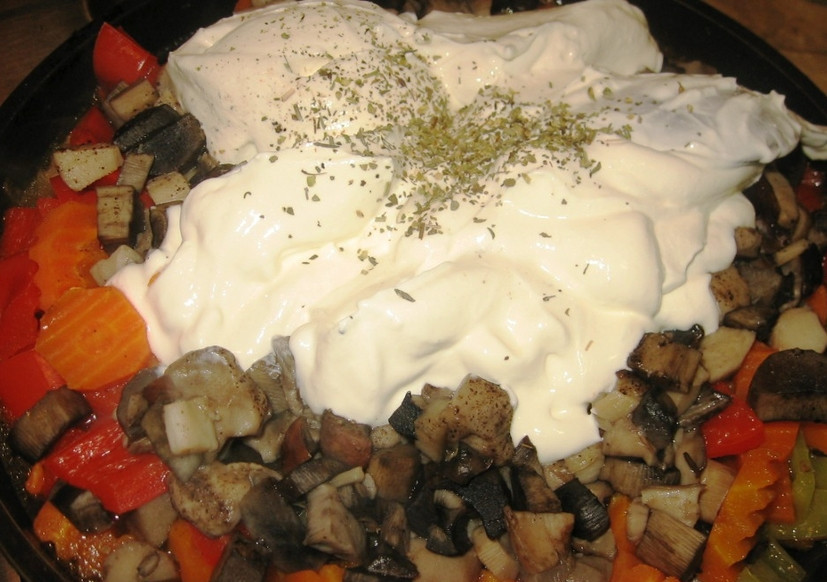 1. Этап. Гуляш из говядины с грибами: На грибы выкладываем сметану, посыпаем все сушеными травами и перемешиваем.