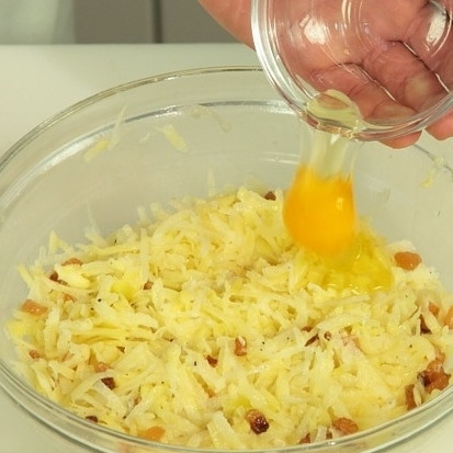 1. Этап. Кугелис: Добавьте яйца, мелко нарезанный лук и специи. Перемешайте.