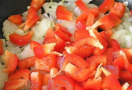 1. Этап. Закуска из яиц в красном соусе: На смеси растительного и сливочного масел обжарьте нарезанный лук, добавьте красный перец, перемешайте, продолжая обжаривать.