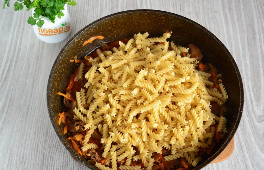 1. Этап. Куриные сердечки с макаронами: За время тушения вода почти испарится, добавьте в сковороду сухие макароны.