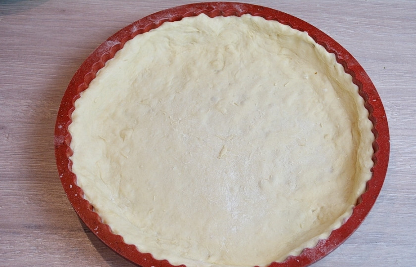 1. Этап. Киш классический: Подошедшее тесто нужно обмять. Добавьте 50-70 граммов муки, раскатайте и уложите в форму. Лишнее тесто обрежьте.