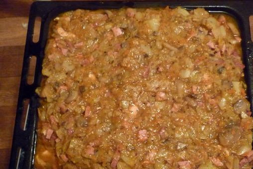 1. Этап. Бигус в духовке: Соединяем тушеную капусту, обжаренное мясо с колбасой, грибы и лук с томатной пастой, перемешиваем все, солим и приправляем специями. Полученное ассорти выкладываем на противень и ставим в разогретую духовку минут на 40.