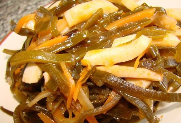 1. Этап. Солянка из морской капусты: В отдельной кастрюле вскипятим воду, бросим в кипяток морскую капусту, помешаем, и накроем крышкой на одну минуту. После этого достанем капусту, добавим её в сковороду к остальным ингредиентам. Перемешиваем все и раскладываем по тарелкам. Блюдо готово к подаче!