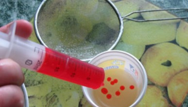 1. Этап. Икра из желатина для торта: Набираем загустевшее желе в шприц без иголки и начинаем капать в стакан с холодным маслом. Капли желе будут охлаждаться и падать на дно стакана.