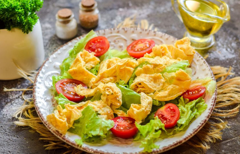 1. Этап. Теплый салат с печенью и омлетом: На тарелку выложите чистые салатные листья, добавьте омлет и нарезанные дольками черри.