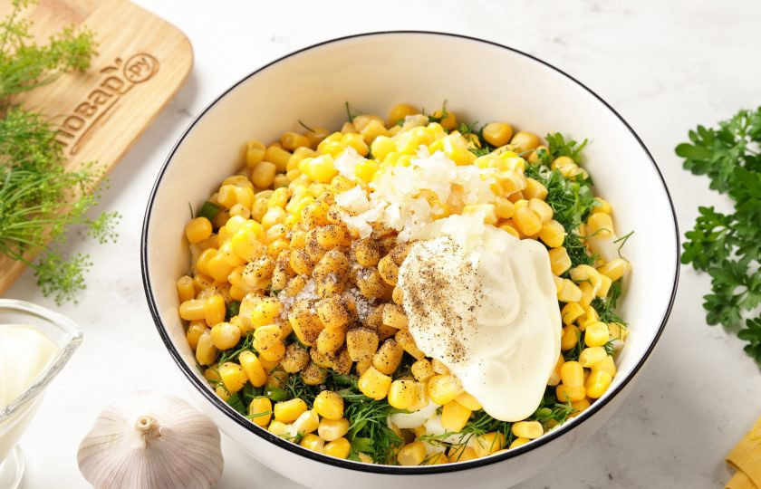 1. Этап. Салат с яйцом, сыром, кукурузой и огурцом: Заправьте салат майонезом, посолите и поперчите по вкусу, добавьте давленый чеснок.