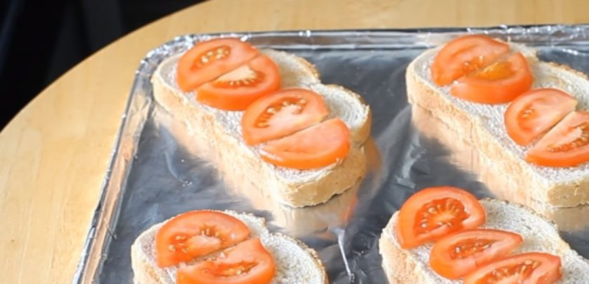 1. Этап. Горячие бутерброды со шпротами, помидорами и сыром: 2. Выложите хлеб на покрытый фольгой противень. На батон выложите нарезанные дольками помидоры. Затем выложите нарезанные пластинками сыр и шпроты.