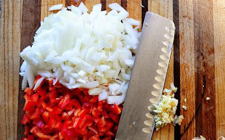 1. Этап. Индейка и салат-латук: Сначала порежьте лук, красный перец и чеснок.