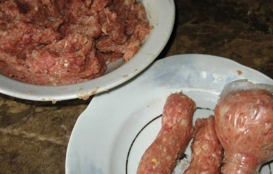 1. Этап. Большая сосиска в беконе: Мелко измельчите лук и чеснок, пропустите с фаршем. Посолите и поперчите. Колбаски хорошо формируются, если их пропустить через горлышко бутылки.