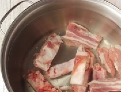 1. Этап. Рассольник из свинины: Выкладываем свиные рёбра в кастрюлю и заливаем их водой. Ставим на сильный огонь, когда вода закипит, снимаем образовавшуюся пену, убавляем газ и варим на медленном огне.