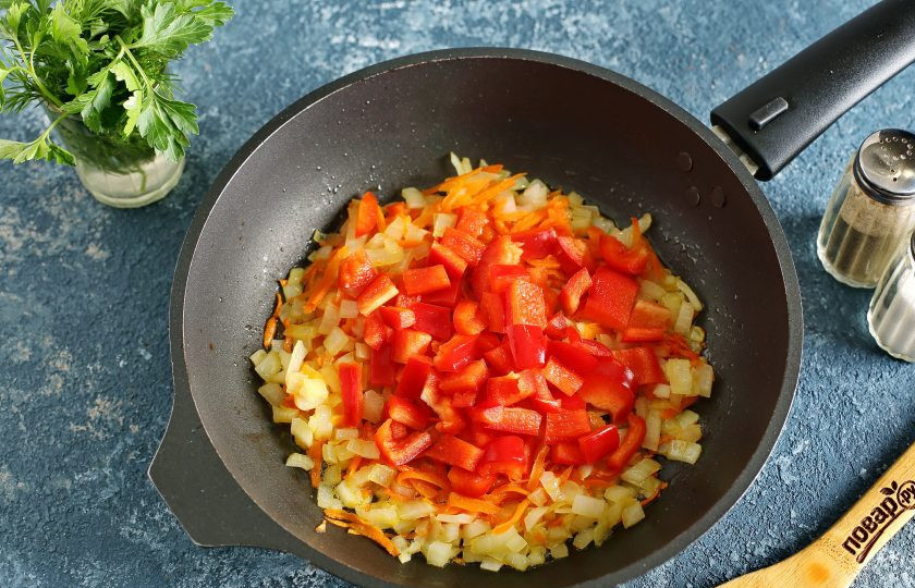 1. Этап. Куриный суп по-болгарски: Обжарьте овощи до мягкости и добавьте нарезанный кубиками перец.