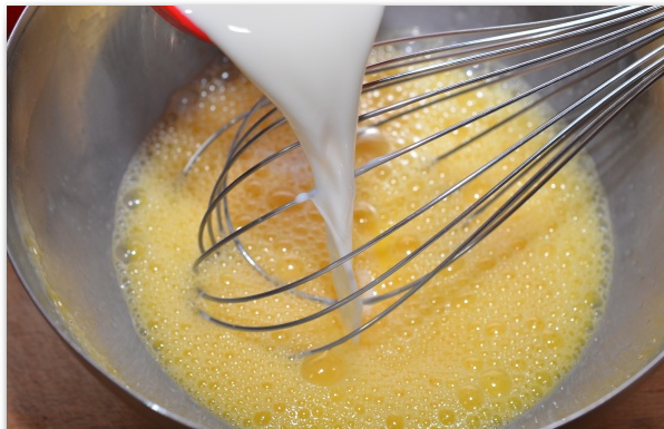 1. Этап. Запеканка из брокколи в духовке: Добавьте молоко и сливки, продолжайте взбивать.