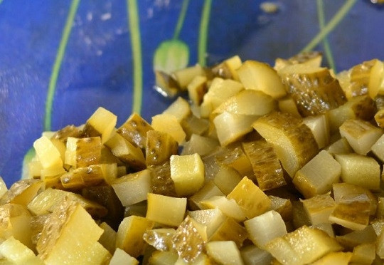 1. Этап. Рассольник с почками: 6. Нарежьте небольшими кубиками огурчики. Выложите в бульон жареные овощи, огурцы и крупу. Варите еще минут 5. Посолите по вкусу, поперчите, добавьте специи.