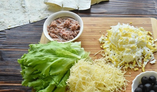 1. Этап. Тунец в лаваше: С тунца сливаю масло и разминаю филе вилкой. Листья салата ополаскиваю водой и просушиваю. Сыр и яйца натираю на терке.