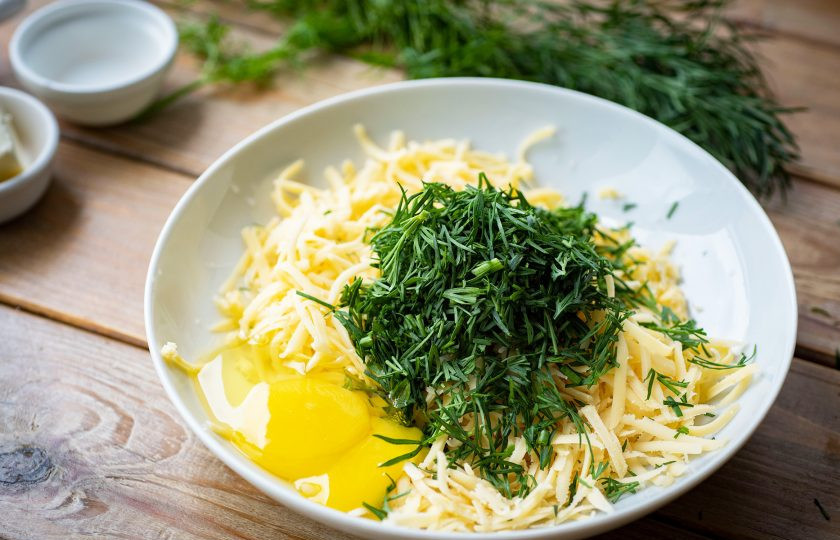 1. Этап. Хачапури на молоке с сыром: В просторную миску натрите твердый сыр, добавьте мелко порубленный укроп, вбейте яйцо.