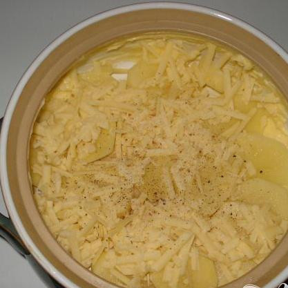 1. Этап. Выпечка из сыра и картофеля: Смазать маслом блюдо для выпечки (дно и по краям. Уложить картофель на дно блюда и посыпать сверху тёртым сыром и приправами.