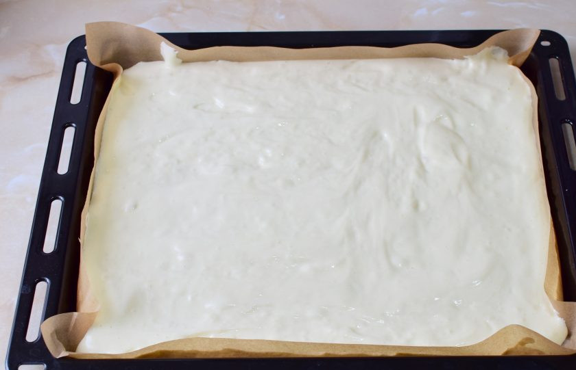 1. Этап. Бисквитный рулет с кремом из сливок: Противень 30 на 40 см. застелите пергаментом и вылейте тесто. Равномерно распределите его по всей поверхности.