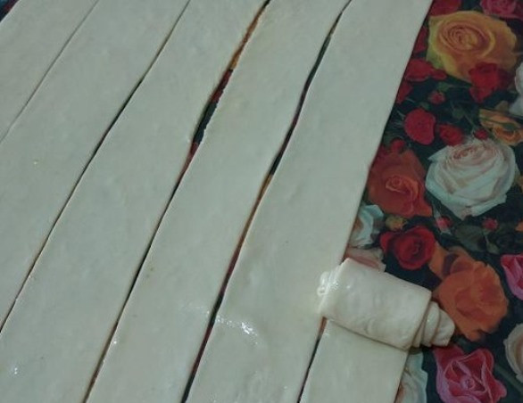 1. Этап. Булочки на пару: Затем нарежьте тесто полосками шириной около 3 см. Затем скатайте полоски в рулетики.