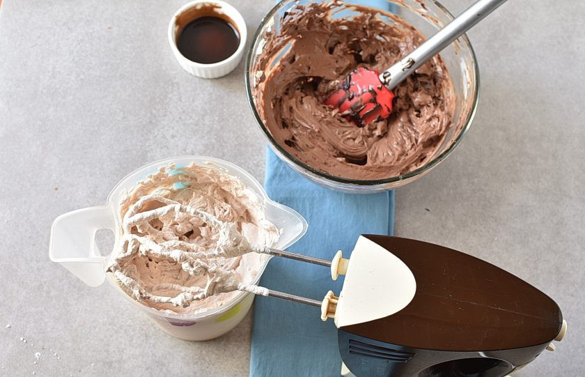 1. Этап. Шоколадный Чизкейк: Отдельно взбейте густые холодные сливки до жестких пиков, добавив остаток сахарной пудры и шоколадного сиропа, а так же 2 столовых ложки какао-порошка. Вмешайте треть сливок в крем-чиз легкими движениями.