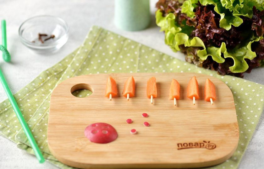 1. Этап. Новогодний завтрак Веселый кролик: Из морковки вырежьте ушки, из ломтика редиса — носик. Носик я вырезала пластиковой коктейльной трубочкой. Вставьте в ушки зубочистки.