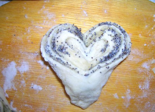 1. Этап. Плюшки с маком: Разворачиваем плюшку. Она получается в форме сердечка. Выкладываем на противень, смазанный маслом и даём подойти 10 минут в теплом месте.