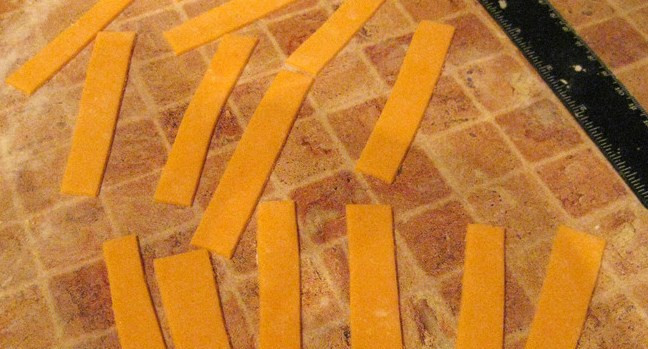 1. Этап. Торт на день рождения мальчику: Теперь займемся бантом. Из оранжевой мастики раскатываем пласт и нарезаем одинаковые полоски. Чем больше полосок, тем пышнее будет бант.