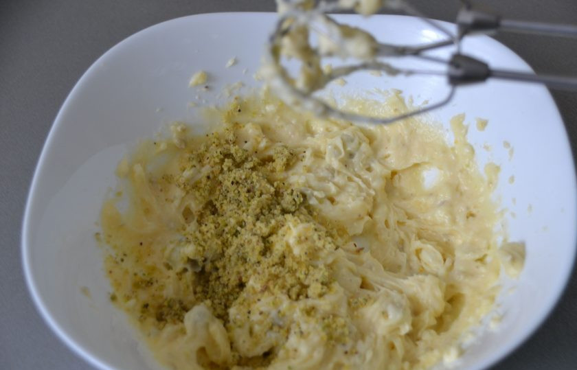 1. Этап. Фисташковые эклеры: В охлажденный заварной крем раскрошите фисташковую пасту, добавьте 40 грамм сливочного масла комнатной температуры, взбейте.