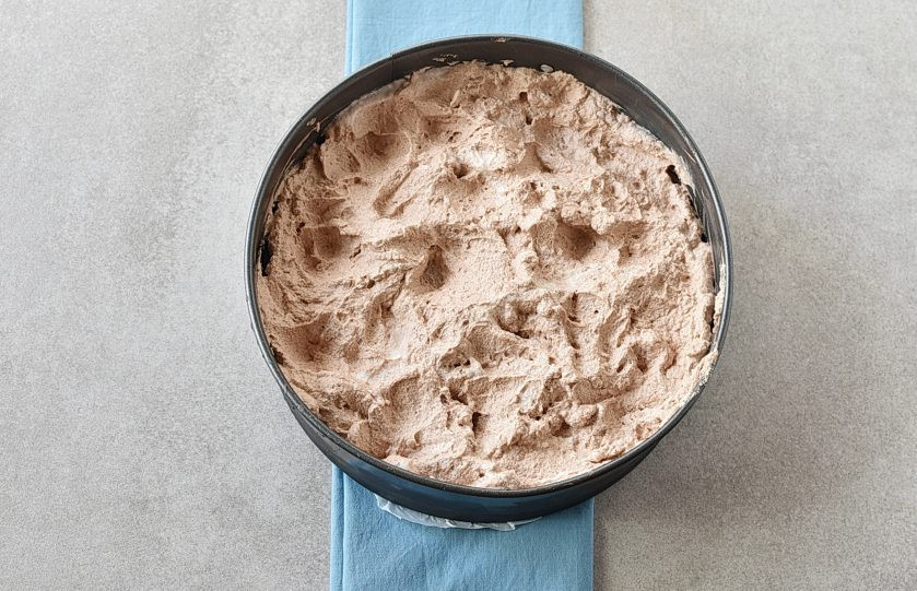 1. Этап. Шоколадный Чизкейк: Извлеките чизкейк и покройте слоем взбитых шоколадных сливок. Уберите в морозилку еще на полчаса.