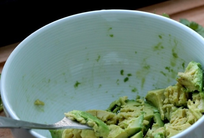 1. Этап. Закуска из батата с гуакамоле: 2. Ложкой достаньте мякоть из двух половинок авокадо, добавьте лимонный сок и сок лайма, разомните вилкой. Добавьте измельченную кинзу и чеснок, соль и перец.