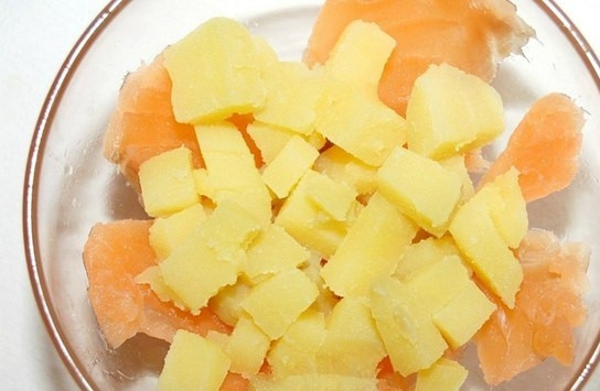 1. Этап. Салат с форелью: Порежьте форель на некрупные кусочки и выложите их на дно тарелки. Отварите картофель в мундире. Посолите его. После того, как картофель сварится, остудите и очистите его. Порежьте на мелкие кубики и положите поверх рыбы.