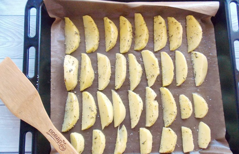 1. Этап. Картофельные дольки с чесноком: На противень с пекарской бумагой выложите картофельные дольки.