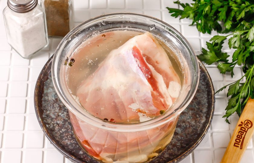 1. Этап. Пузанина в рассоле с чесноком: Промойте мясо в воде, соскоблите кожу и выложите его в емкость, чтобы оно полностью покрылось рассолом. Можно добавить гнет, если мясо всплывает. Поместите емкость в холодильник на 2-3 дня. Несколько раз в течение этого времени переверните мясо, чтобы оно равномерно просолилось.