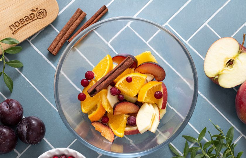 1. Этап. Холодный пунш: Переложите подготовленные фрукты в глубокую чашу для пунша. Добавьте палочки корицы и клюкву.