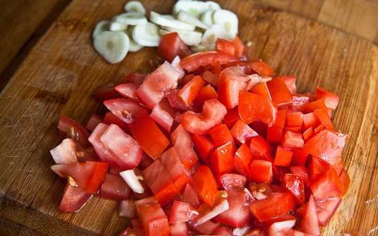 1. Этап. Вкусный фасолевый суп: 5. Параллельно вымойте и обсушите помидоры, нарежьте их кубиками. Очистите и измельчите чеснок.