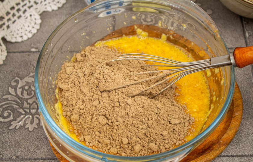 1. Этап. Льняной кето-хлеб: Всыпьте половину льняной муки, перемешайте тесто.