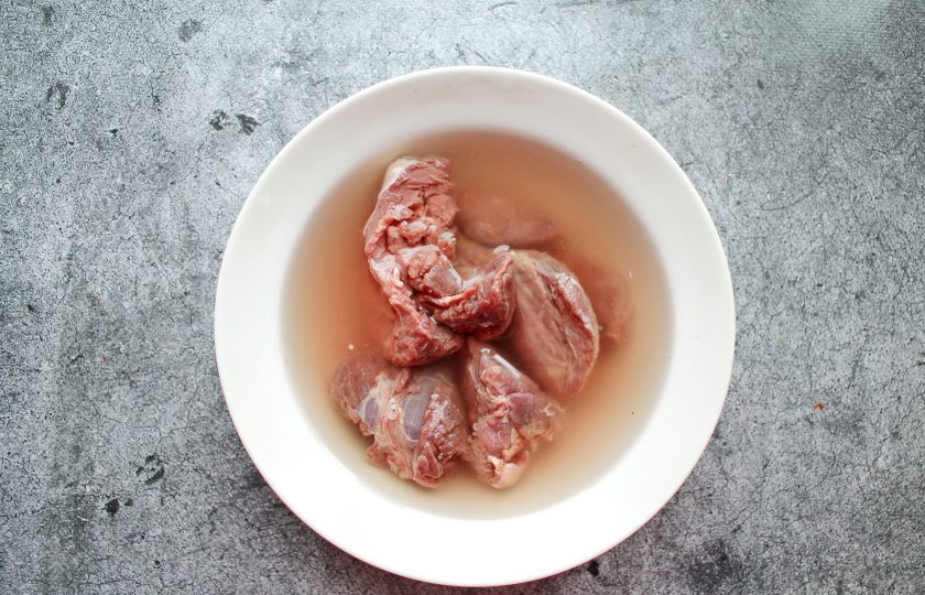 1. Этап. Оленина с картошкой в духовке: Вымачивайте мясо оленя в холодной воде в течение 12 часов, меняя воду 2-3 раза.