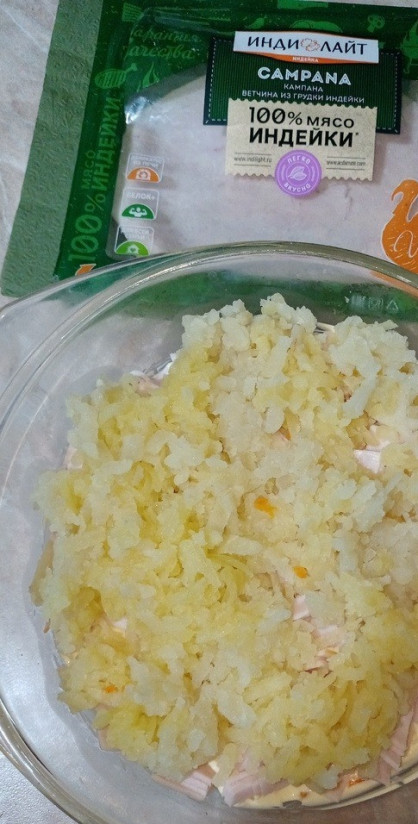 1. Этап. Сытный и ходовой салат с ветчиной: На ветчину выкладываем натёртую картошку, вареную и остуженную, майонезом смазываем.