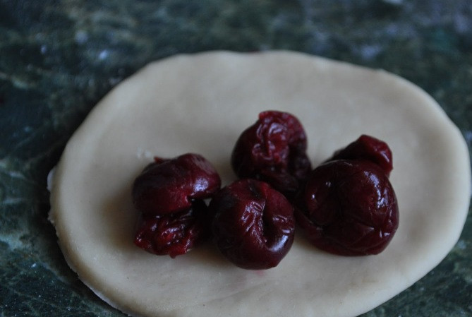 1. Этап. Вареники с вареньем: Теперь поочередно раскатываем каждый кусочек теста в тонкий пласт и вырезаем из него небольшие кружочки, в середину каждого круга кладем немного начинки.