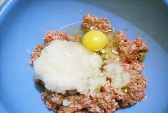 1. Этап. Картофельные шарики с начинкой: подготовьте начинку. В фарш добавьте тертый на мелкой тёрке лук, соль, перец и яйцо. Тщательно перемешайте.