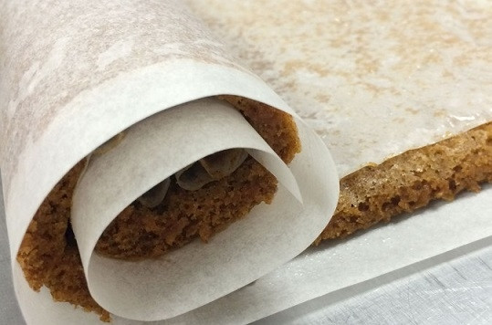 1. Этап. Тыквенный рулет с кремом: 5. Остудите бисквит пару минут в форме. После сверху накройте еще одним листом пергамента и аккуратно сверните в рулет. Оставьте его в таком виде остывать.