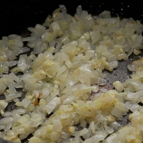 1. Этап. Лазанья с мясом: Лук и чеснок мелко нарезать. Разогреть в сковороде немного оливкового масла, добавить лук с чесноком и готовить на умеренном огне, помешивая, до мягкости. Примерно 10 минут.