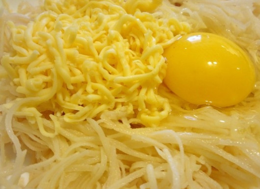 1. Этап. Тарталетки из картофеля: В миску с картофелем разбиваем 1 яйцо и добавляем тертый на крупной терке сыр. Солим и посыпаем специями, тщательно перемешиваем. Я обычно использую из специй только черный молотый перец, так как он подходит к любой начинке, но вы можете выбрать те специи, которые будут особенно удачно сочетаться с вашим наполнителем.