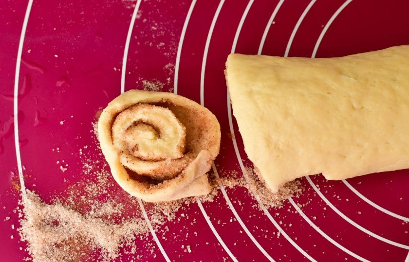 1. Этап. Печенье на кефире с корицей: Скрутите пласт рулетиком и нарежьте его на кусочки.